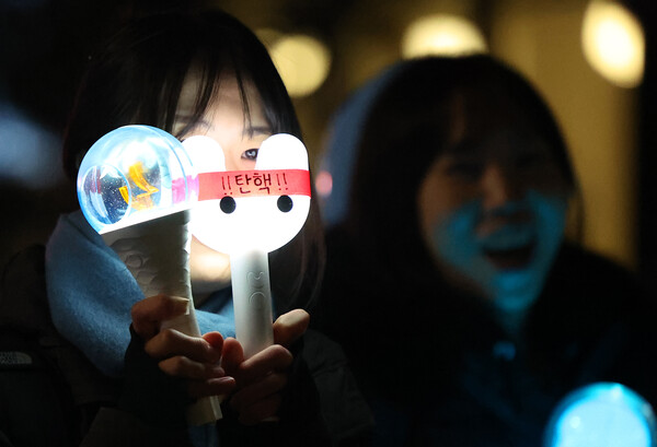 윤석열 대통령 탄핵소추안이 가결된 12월 14일 서울 여의도 국회 앞에서 열린 촛불집회에서 한 참가자가 탄핵 문구가 적힌 응원봉을 들고 있다. ⓒ연합뉴스