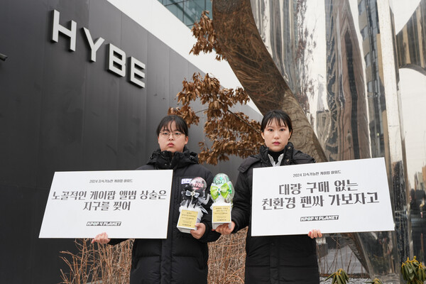 케이팝포플래닛이 16일 오전 서울 용산구 하이브 사옥 앞에서 하이브에 과도한 앨범판매 상술 중단을 요구하는 ‘응원봉 트로피 전달’ 퍼포먼스를 벌였다. (왼쪽부터)김나연, 박진희 케이팝포플래닛 캠패이너. ⓒ케이팝포플레닛