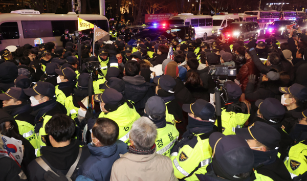 내란 우두머리 혐의로 체포된 윤석열 대통령의 구속 전 피의자심문(영장실질심사)이 종료된 18일 서울 마포구 서부지법 인근 공덕오거리에서 법무부 호송차가 지나가고 있는 가운데 윤 대통령 지지자들이 경찰과 몸싸움을 벌이고 있다. ⓒ연합뉴스