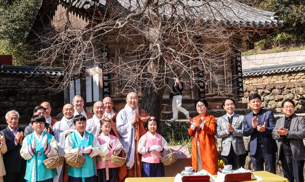 시인 현중순씨(오른쪽부터 네 번째)의 시비(詩碑)가 지난 3월 22일 전남 구례군 화엄사 각황전 홍매화 아래 건립됐다. 홍매화의 아름다움과 굳은 절개를 예찬한 시비는 높이 1m, 폭 0.7 크기의 동판으로 헌정시 ‘거룩한 법신 각황매여’가 새겨져 있다.  ⓒ연합뉴스