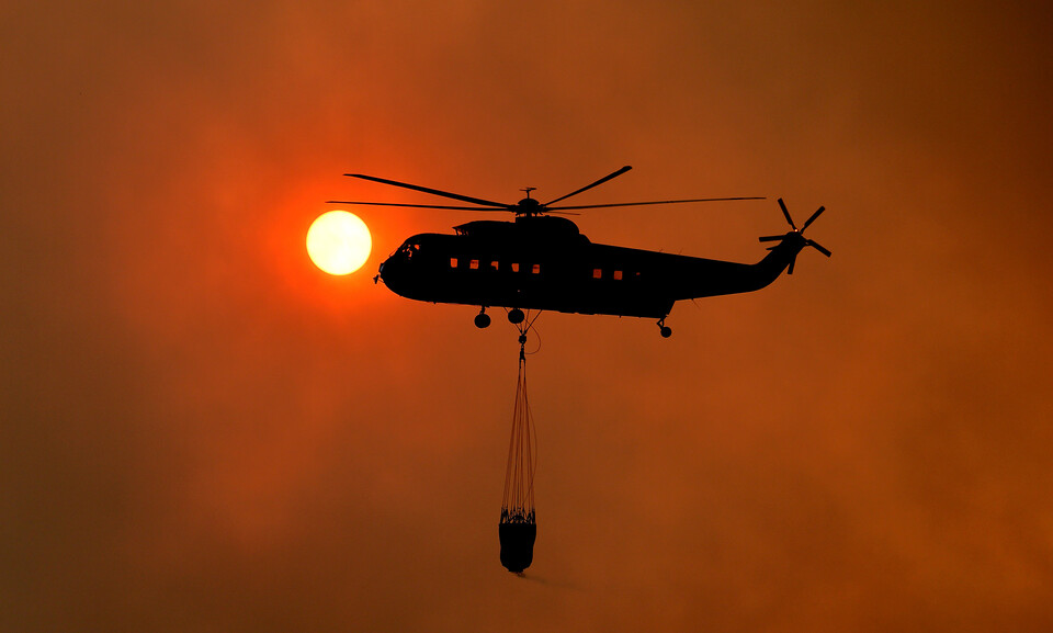 경북 의성군 산불 발생 사흘째인 24일 점곡면 명고리 한 야산에서 오후 해질 무렵에 산불진화헬기가 해를 배경으로 진화작업을 하고 있다. ⓒ뉴시스·여성신문