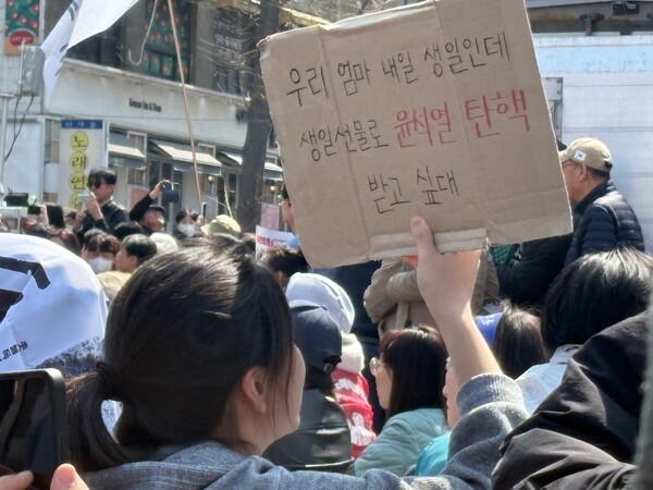 4일 탄핵찬성 집회에 참여한 한 참가자 '우리 엄마 내일 생일인데 생일선물로 윤석열 탄핵 받고 싶대'라고 적힌 피켓을 들고 있다. ⓒ신다인 기자