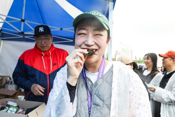 농업회사법인 (주)한백식품의 프리미엄 김 브랜드 박향희김이 3일 서울 마포구 상암 월드컵공원 평화광장에서 열린 ‘2025 여성마라톤 대회’에 참가했다. 한 참가자가 박향희김으로 만든 주먹밥을 맛보고 있다. ⓒ손상민 기자