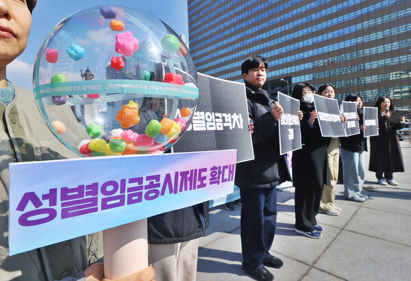 직장갑질119 젠더특위, 노동인권실현을위한노무사모임, 직장갑질119 온라인노조 젠더팀 관계자들이 6일 서울 종로구 광화문 이순신 동상 앞에서 열린 3월 8일 여성의 날 기념 기자회견에서 퍼포먼스를 하고 있다.ⓒ연합뉴스