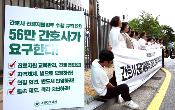 신경림 대한간호협회 회장(가운데)을 비롯한 전국 시도간호사회와 산하단체 회원들이 20일 정부세종청사 보건복지부 정문 앞에서 기자회견을 열고 정부의 진료 지원 업무 관련 교육책임을 병원에 전가하려는 시도에 대해 강력하게 반발하고 있다. 이들은 "간호사의 진료 지원업무 교육 관리는 간호 실무와 교육에 전문성을 갖춘 대한간호협회가 책임져야 한다"고 주장하며 정부의 일방적인 제도 추진을 비판했다.  ⓒ연합뉴스