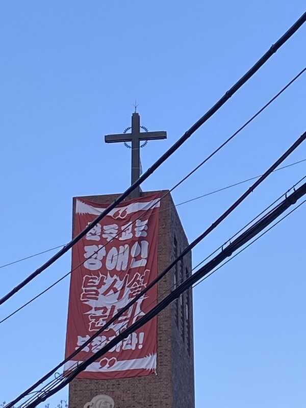 전국탈시설장애인연대와 전국장애인차별철폐연대 등 활동가들이 장애인 거주 시설을 다수 운영하는 한국 천주교가 탈시설 권리를 거부하고 있다고 항의하며 18일부터 천주교 서울대교구 혜화동성당 종탑에서 고공농성에 들어갔다.  ⓒ정보라 작가 제공