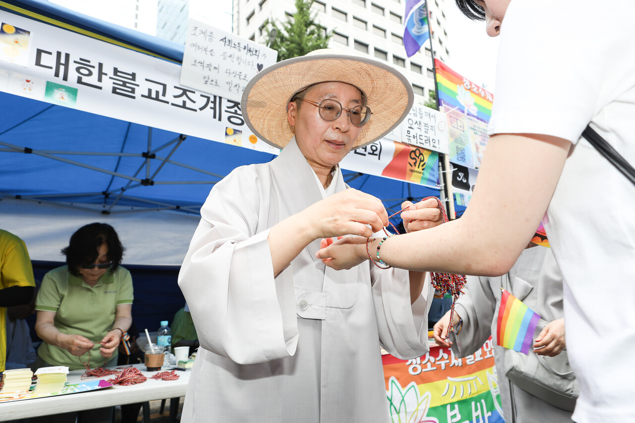 14일, 서울 종로구 우정국로와 남대문로 일대에서 열린 제26회 서울퀴어퍼레이드에 부스로 참여한 대한불교조계종 사회노동위원회 소속 승려가 참여자에게 팔찌를 매주고 있다. ⓒ손상민 사진기자