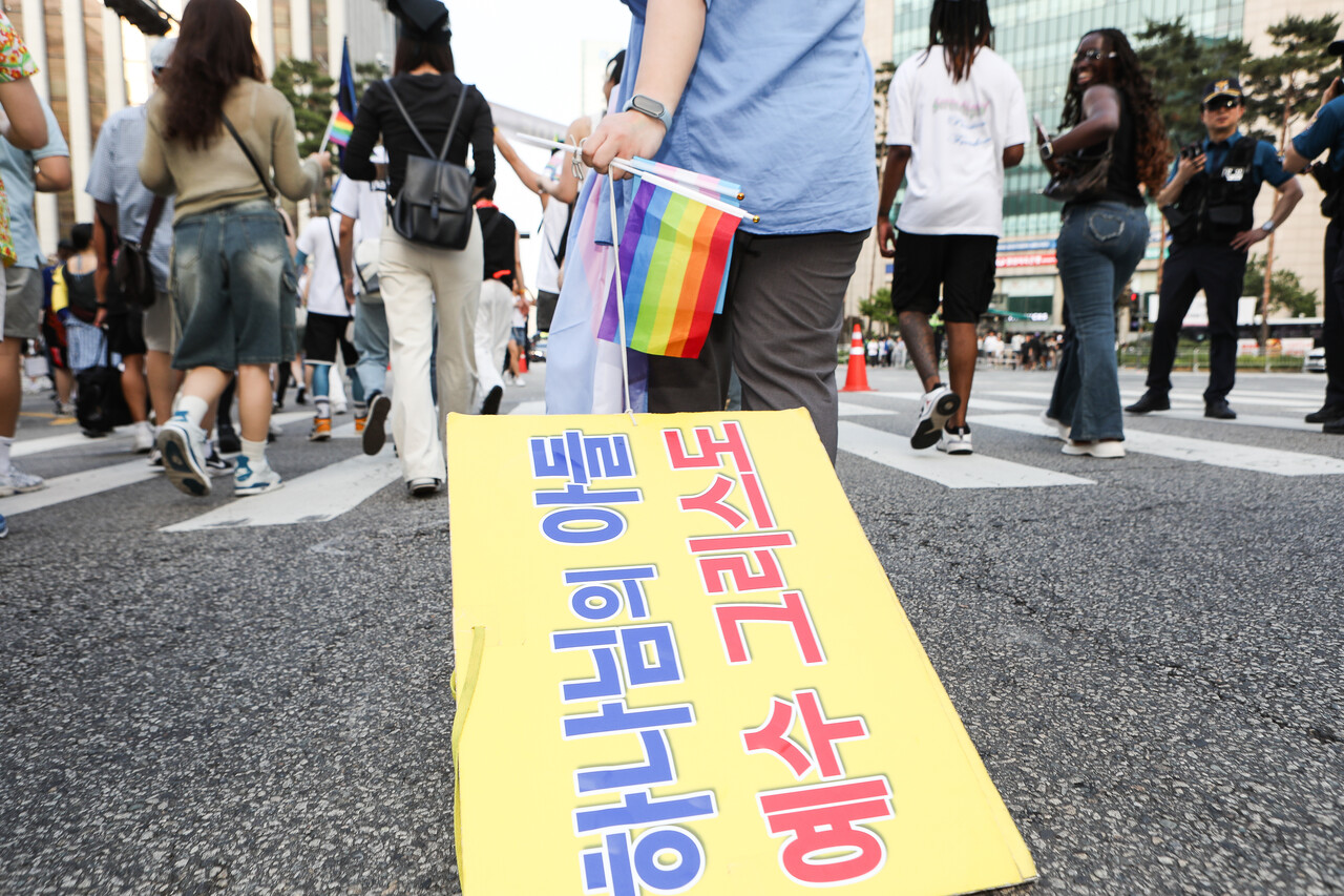 14일, 서울 종로구 우정국로와 남대문로 일대에서 열린 제26회 서울퀴어퍼레이드에서 행진 중 바닥에 떨어진 혐오세력의 피켓을 주워 옮기고 있는 참여자. ⓒ손상민 사진기자