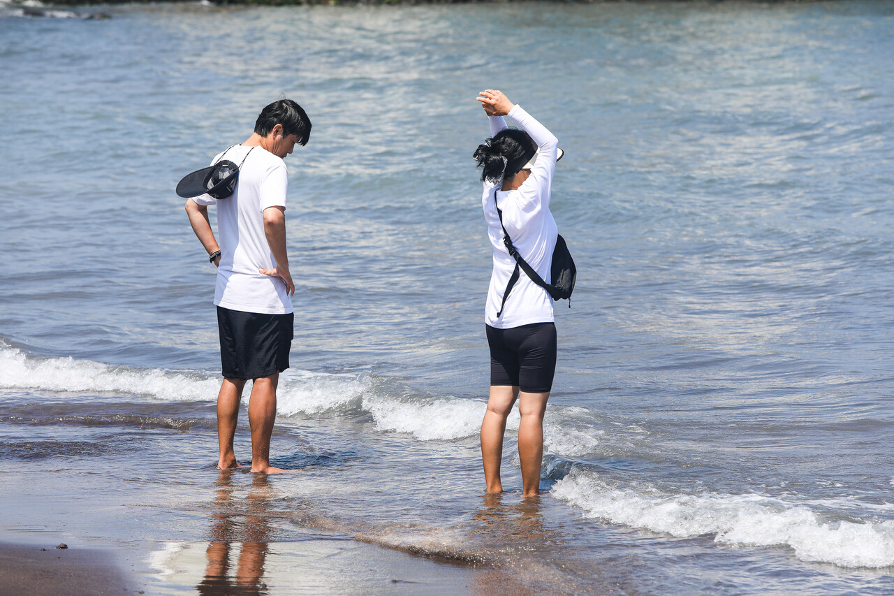4일 제주시 삼양검은모래해변에서 시민들이 바다에 발을 담그고 바다를 보고 있다. ⓒ손상민 사진기자