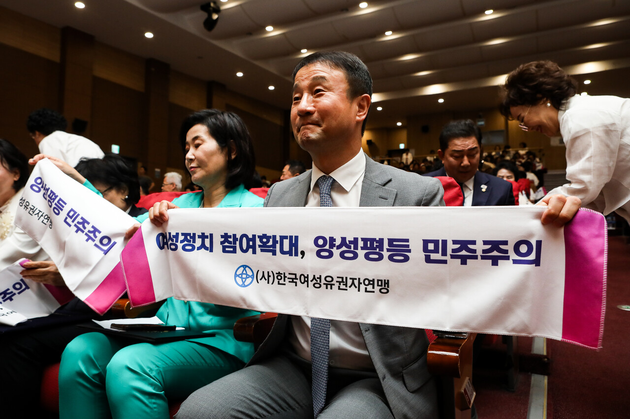 22일 서울 영등포구 국회의사당 의원회관 대회의실에서 열린 한국여성유권자연맹 제56주년 창립기념식과 중앙회장 이·취임식에서 한병도 예산결산특별위원장이 '여성정치 참여확대, 양성평등 민주주의'가 적힌 피켓을 들고 있다. ⓒ손상민 사진기자