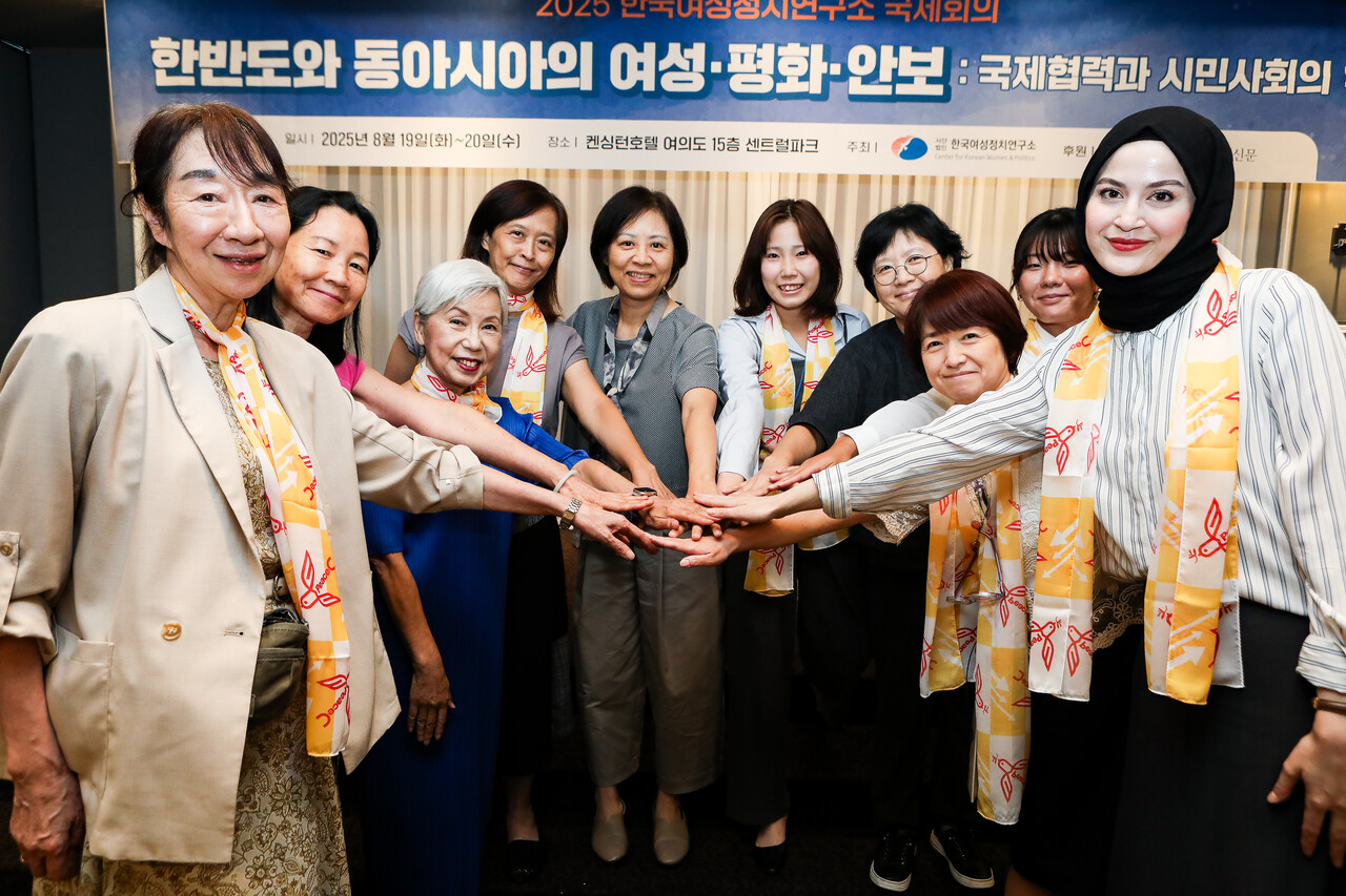 20일 서울 영등포구 켄싱턴호텔에서 열린 ‘2025 한국여성정치연구소 국제회의’에서 참여자들이 손을 가운데로 모으고 여성·평화·연대를 외칠 준비를 하고 있다. ⓒ손상민 사진기자
