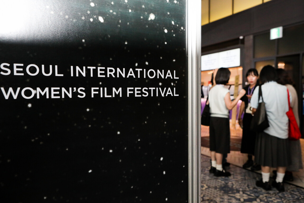 21일 서울 서대문구 신촌 메가박스에서 열린 제27회 서울국제여성영화제 개막식에서 영화제 이름이 적힌 판넬 뒤로 여성들이 이야기를 하고 있다. ⓒ손상민 사진기자