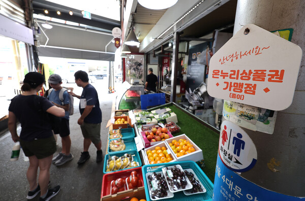 정부가 민생회복 소비쿠폰 1차 지급계획을 발표한 지난 7월 6일 서울의 한 전통시장 점포에 기존 골목경제 소비 활성화를 위한 온누리상품권 가맹 팻말이 붙어 있다. ⓒ연합뉴스