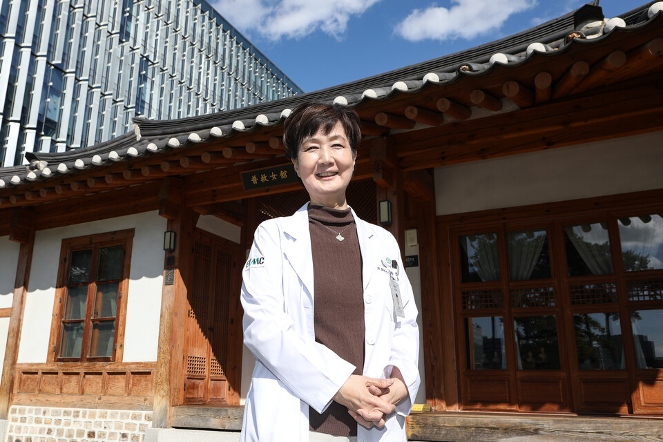 한옥식 보구녀관 앞에선 유경하 이화의료원장 뒤로 현대식 건물의 이대서울병원이 보인다. 유 원장은 “소외된 여성과 약자를 돌보기 위해 설립된 보구녀관은 섬김과 나눔이라는 이화의료원 설립 가치를 교직원들과 공유하는 거점으로서 중요한 역할을 하고 있다”고 설명했다. ⓒ손상민 사진기자