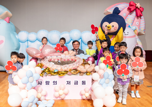 진교훈 서울 강서구청장(가운데)이 지난 3월 강서구민회관 우장홀에서 열린 ‘사랑의 저금통 마음모으기’ 전달식에서 아이들과 함께 기념을 하고 있다. ⓒ강서구