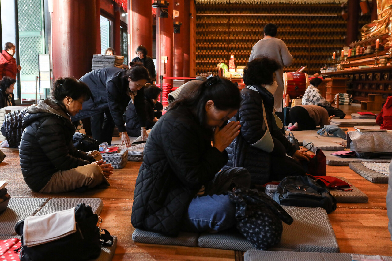 2026학년도 대학수학능력시험(수능)을 하루 앞둔 12일, 서울 중구 조계사에서 자녀의 고득점을 기원하는 수험생 가족들이 기도를 하고 있다. ⓒ손상민 사진기자