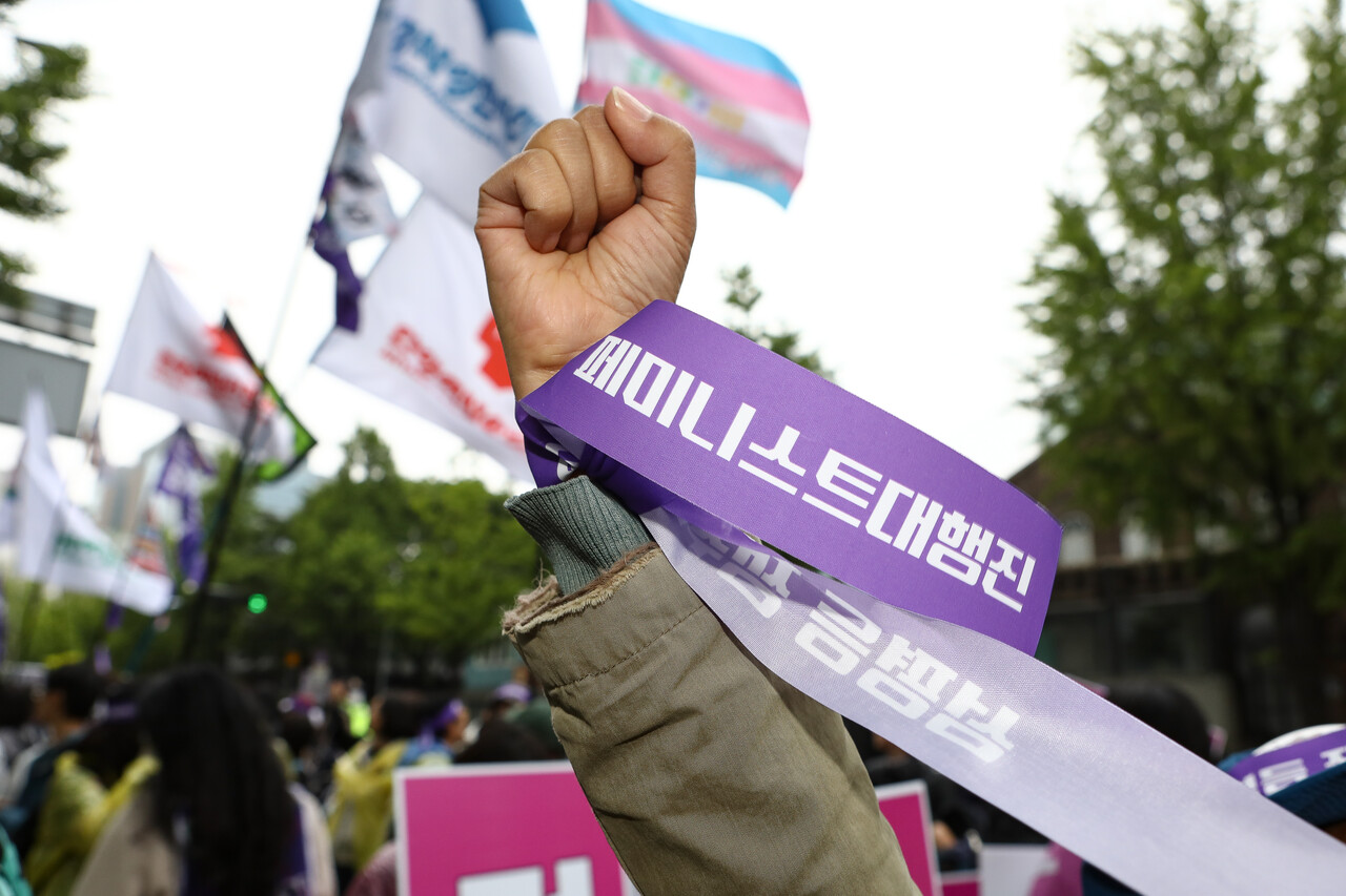 지난 5월 10일 '윤석열 파면한 페미니스트 대행진'에서 참여자가 문구가 적힌 끈을 손목에 묶고 구호를 외치고 있다. ⓒ손상민 사진기자