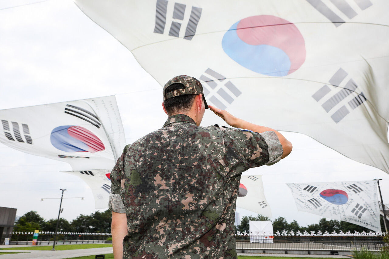 대형 태극기들 앞에서 한 군인이 경례를 하고 있다. 본 사진은 칼럼 내용과 무관. ⓒ손상민 사진기자