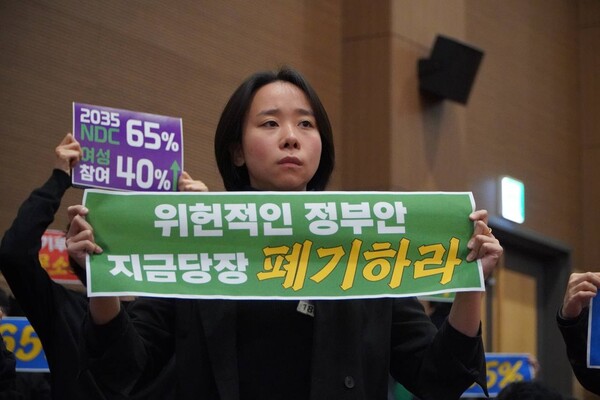 김혜미 녹색당 당원이 이재명 정부가 지난 11일 발표한 ‘2035 국가 온실가스 감축 목표’(2035 NDC)를 하한 50% 또는 53%, 상한 60%라는 두 가지 안에 대해 반대 피켓을 들고 있다. ⓒ장혜영 제공