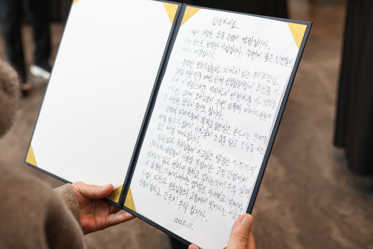 '여성폭력 추방주간'(11월25일~12월 1일)을 맞아 서울 동작구 서울여성플라자에서 25일 성평등가족부와 한국여성인권진흥원이 주관한 ‘2025년 여성폭력 추방주간’ 기념식에서 최말자씨가 자필로 적은 소감문을 확인하고 있다. ⓒ손상민 사진기자
