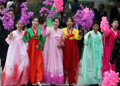 곱게 한복을 차려 입은 평양 여성들이 지난 10월 ‘2007년 남북정상회담’을 위해 방북한 남측 관계자들을 태운 버스를 향해 꽃술을 흔들며 환영하고 있다. ⓒ청와대사진기자단