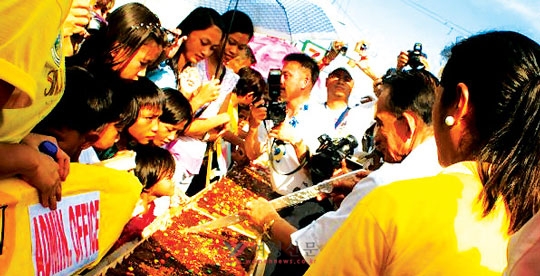 필리핀 로사리오 바탕가스시 시장이 피에스타에 참가해 찹쌀로 만든 대형 떡 ‘시눅마니’를 자르고 있다.