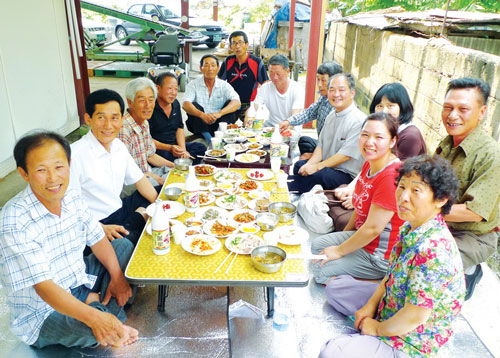 대구시 상동 마을회관에서 동경민씨 가족과 마을 주민들이 즐겁게 둘러 앉아있다.
