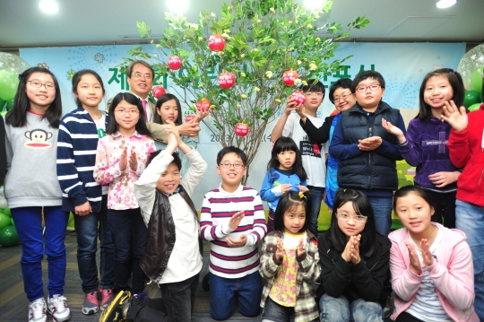 서울 무교동 초록우산 어린이재단 본부에서 지난달 열린 어린이주간 선포식에 참석한 어린이들이 희망나무 앞에서 박수를 치고 있다. 초록우산 어린이재단 제공