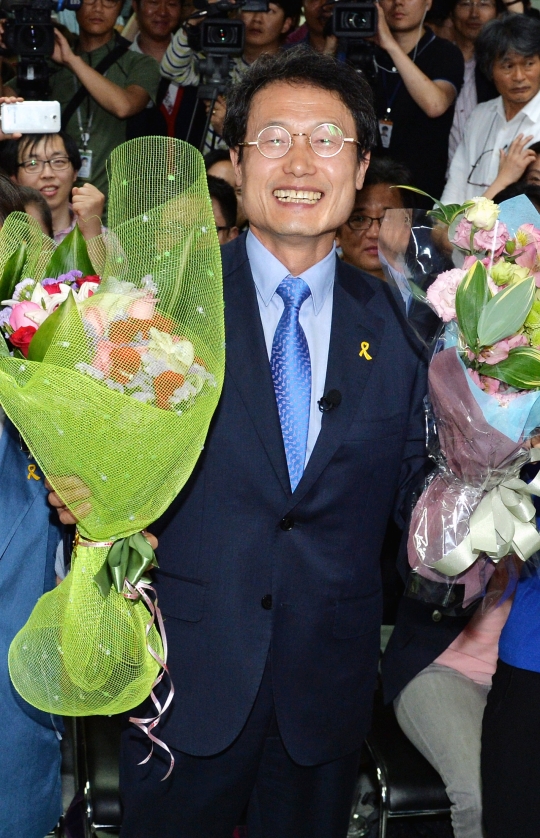 서울시교육감에 당선된 조희연 후보가 꽃다발을 들고 환하게 웃고 있다. ⓒ뉴시스‧여성신문