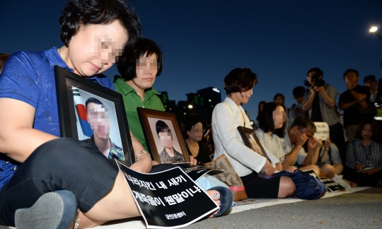 8일 오후 서울 용산구 국방부 앞에서 열린 28사단 고 윤일병 구타 사망사고 추모제에서 피해자 가족들이 희생자들의 영정 사진을 들고 슬퍼하고 있다. ⓒ뉴시스·여성신문