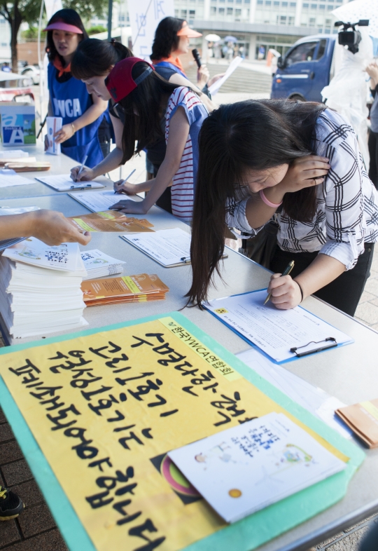 19일 서울 중구 명동에서 한국YWCA연합회 회원들이 시민들을 상대로 탈핵과 탈원전 캠페인을 펼치고 있는 가운데 지나가던 시민이 서명을 하고 있다. ⓒ이정실 여성신문 사진기자