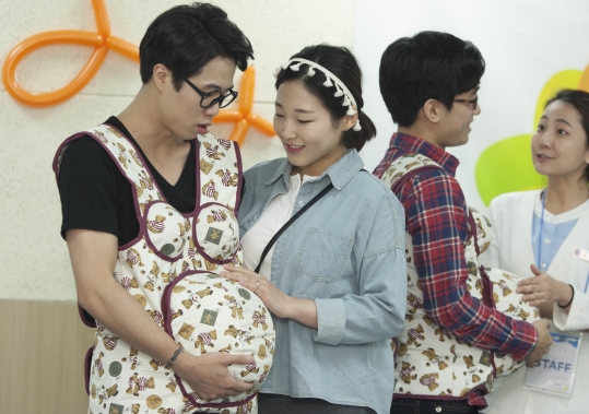 7일 서울 송파구 장지동 송파산모건강증진센터에서 열린 2014 임산부의 날 행사에서 한 남성이 임신체험복을 착용해보고 있다.