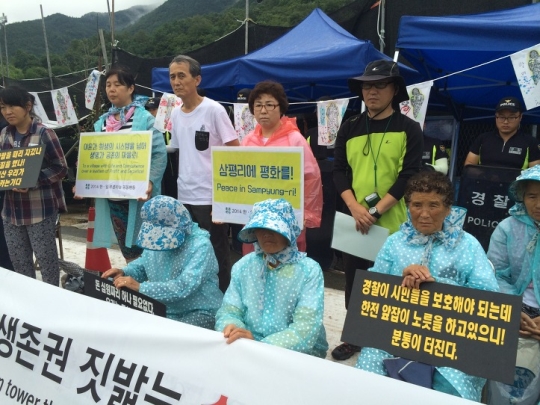 송전탑 건설에 반대해온 할머니들과 주민들이 경찰을 규탄하는 시위를 하고 있다.