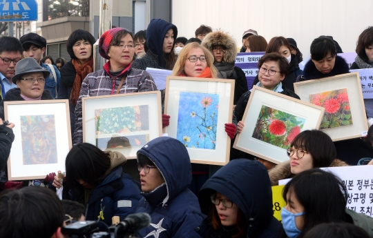 9일 오후 서울 종로구 구 주한일본대사관 앞에서 열린 일본군‘위안부’ 문제 해결을 위한 정기 수요시위에서 참석자들이 ‘평화의 소녀상’ 그림을 들고 일본의 공식사과를 촉구하고 있다.