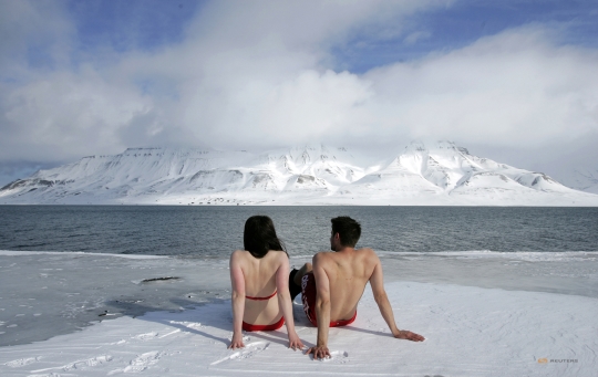 2007년 4월 25일, 환경운동가인 레슬리 버틀러와 롭 벨이 노르웨이 북극 지역인 롱웨이아르뷔엔의 피오르드 빙하조각의 가장자리에서 일광욕을 하고 있다. 환경운동가들은 지구 온난화로 북극의 빙하가 녹고 인간이 수영과 일광욕을 할 수 있을 정도로 바다 온도가 올라감에 대해 경고하고 있다. ⓒ로이터 사진전 사무국