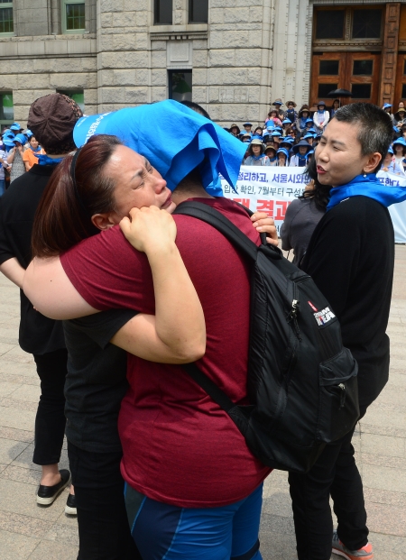 14일 오후 서울 중구 서울시청 앞에서 열린 발달장애인 부모들의 ‘서울시청 농성투쟁 결과보고대회’에서 참가자들이 서로 포옹하고 있다. ⓒ뉴시스·여성신문