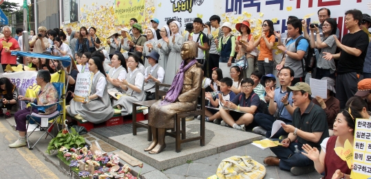 22일 오후 서울 종로구 중학동에서 열린 ‘제1236차 일본군성노예제 문제해결을 위한 정기 수요시위’에 참석한 시민들이 노래에 맞춰 박수를 치고 있다. ⓒ변지은 기자