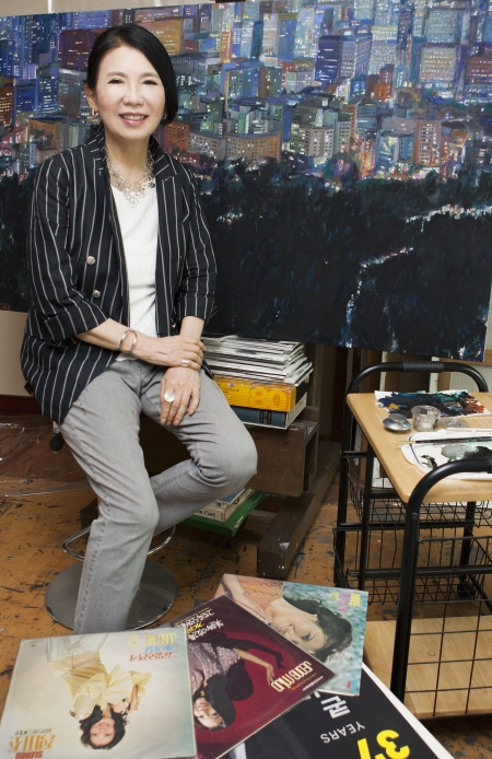 가수 정미조가 3년 전부터 그리고 있는 100호짜리 유화 ‘서울야경’을 배경으로 포즈를 취했다. ⓒ이정실 사진기자