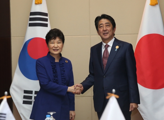 ASEAN+3 정상회담 참석차 라오스를 방문중인 박근혜 대통령과 아베 신조 일본 총리가 7일 오후(현지시간) 라오스 비엔티안 국립컨벤션센터에서 양자회담 전 악수하고 있다. ⓒ뉴시스·여성신문