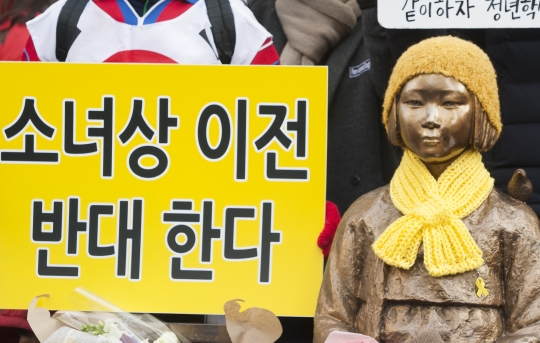 지난해 12월 30일 서울 종로구 일본대사관 앞에서 열린 ‘1211차 정기 수요시위 및 일본군 위안부 피해 할머니들 추모제’에서 참석자들이 소녀상이전 반대 피켓을 들고 있다.. ⓒ이정실 여성신문 사진기자