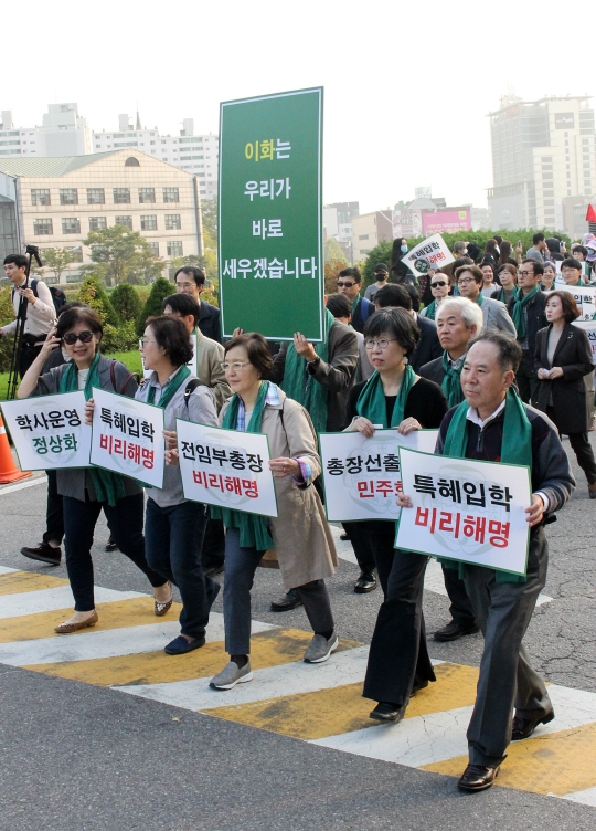 최경희 이화여대 총장이 사퇴한 19일 서울 서대문구 이화여자대학교에서 교수들이 기자회견을 마친 뒤 손팻말을 들고 행진하고 있다. ⓒ변지은 기자