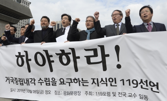 28일 서울 종로구 광화문 광장에서 119포럼 주최로 진행된 대통령 하야와 거국중립내각 수립을 요구하는 지식인 119선언에 참가한 교수들이 구호를 외치고 있다.