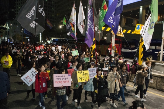 19일 서울 광화문광장 일대에서 열린 박근혜 대통령 퇴진을 촉구하는 ‘4차 민중총궐기에 참여한 여성들이 깃발과 손팻말을 들고 행진하고 있다.