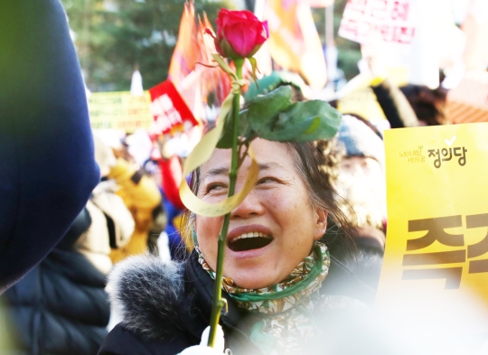 박근혜 대통령 탄핵안 가결이 발표되는 순간 국회 앞 거리에서 야외스크린을 통해 숨죽이고 뉴스를 지켜보던 시민들은 모두 자리에서 일어나 손팻말을 흔들며 함성을 질렀다. ⓒ이정실 사진기자