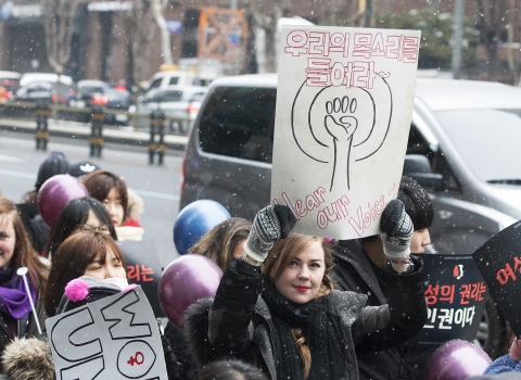 한 외국인 여성이 ‘우리의 목소리를 들어라’라고 적힌 피켓을 들고 행진에 참가하고 있다. ⓒ이정실 사진기자