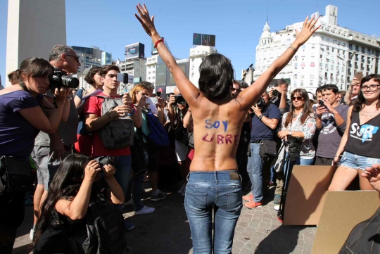 2017년 2월 8일(현지 시간) 아르헨티나의 수도 부에노스 아이레스에서 토플리스 시위가 열린 가운데, 등에 나는 자유다라는 문구를 적은 여성이 카메라를 향해 포즈를 취하고 있다.