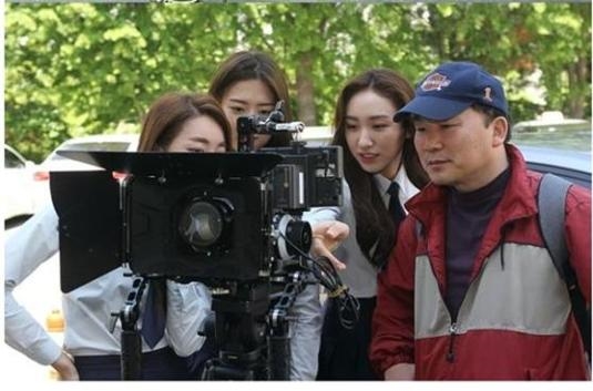 영화 모범생 노홍식 감독(맨 오른쪽)이 배우들과 함께 촬영된 영상을 검토하고 있다.
