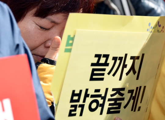 10일 서울 종로구 헌법재판소 앞 도로에서 세월호 유가족이 박 대통령의 탄핵 인용 결정에 눈물을 흘리고 있다. ⓒ뉴시스·여성신문