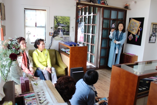 김혜순 대표 (오른쪽 푸른옷 긴머리가) 가 순천재가 만들어지게 된 계기와 내부에 전시된 한복과 소품들에 대해 설명하고 있다.