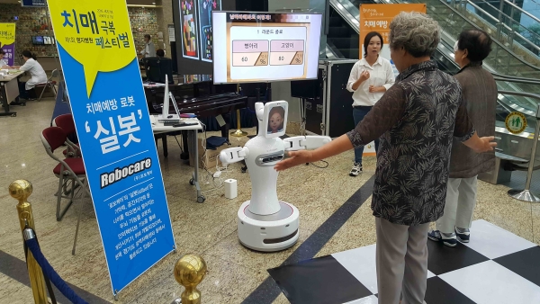 제1회 명지병원 치매극복페스티벌 참가자들이 치매예방 로봇인 실봇을 체험해보고 있다.